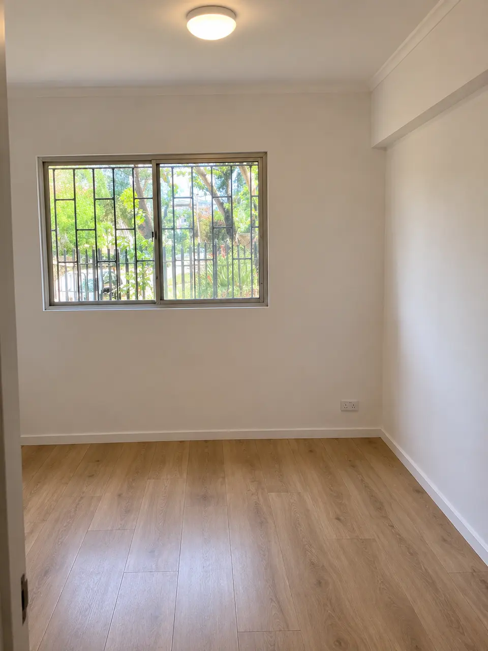 Imagen referencial de habitación renovada con muros blancos y piso de madera
